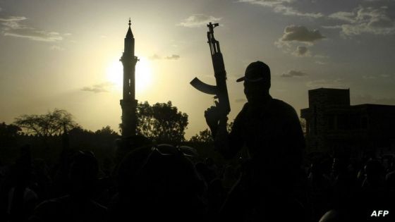 A fighter loyal to Sudan's army chief Abdel Fattah al-Burhan holds up a weapon backdropped by the minaret of a mosque, during a graduation ceremony in the southeastern Gedaref state on May 27, 2024. Sudan has been in the throes of conflict for over a year between the regular army led by de facto ruler Abdel Fattah al-Burhan and the RSF led by his former deputy Mohamed Hamdan Daglo. (Photo by AFP)