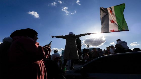 A woman waves an independence-era Syrian flag as people gather at the Umayyad Square in central Damascus to celebrate the ouster of Syrian president Bashar al-Assad on December 13, 2024. Huge crowds also gathered outside a landmark mosque in the Syrian capital Damascus to celebrate during the first Friday prayers since Assad's ouster on December 8. (Photo by Sameer Al-Doumy / AFP)