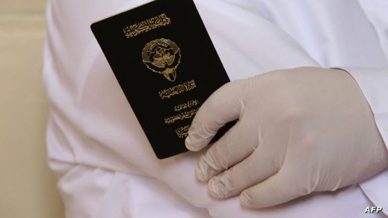 A Kuwaiti man, wearing gloves amid the COVID-19 pandemic, holds his passport as he waits to cast his vote at a polling station in Kuwait City during parliamentary elections on December 5, 2020. Kuwait's parliamentary elections have started under the shadow of Covid-19, with facilities laid on for citizens infected with the disease to vote in special polling stations. The oil-rich country has enforced some of the strictest regulations in the Gulf to combat the spread of the coronavirus, imposing a months-long nationwide lockdown earlier this year. (Photo by Yasser Al-Zayyat / AFP)