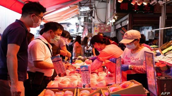 People buy fruits at a stall in Hong Kong's Yau Ma Tei area on July 31, 2021. (Photo by Bertha WANG / AFP)