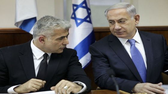 Israeli Prime Minister Benjamin Netanyahu (R) speaks with Finance Minister Yair Lapid during a cabinet meeting in Jerusalem on October 7, 2014. AFP PHOTO / POOL /DAN BALILTY (Photo by DAN BALILTY / POOL / AFP)