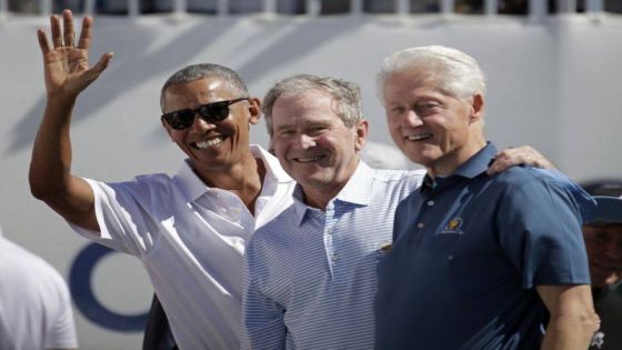 Former U.S. Presidents, from left, Barack Obama, George Bush and Bill Clinton greet spectators on the first tee before the first round of the Presidents Cup at Liberty National Golf Club in Jersey City, N.J., Thursday, Sept. 28, 2017. (AP Photo/Julio Cortez)