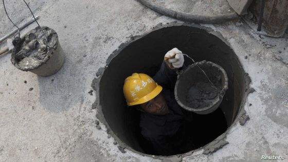 A labourer works in a sewer with cement at a highway viaduct construction site in Hefei, Anhui province April 17, 2011. China's turbo-charged growth eased just a touch in the first quarter, while its inflation jumped to a 32-month high, putting pressure on the government to do more to rein in prices and keep the economy on an even keel. REUTERS/Stringer (CHINA - Tags: BUSINESS CONSTRUCTION)