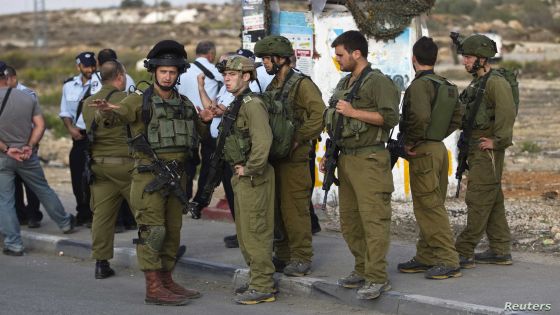 Israeli soldiers stand at the scene where a Palestinian man is suspected of carrying out a running over and stabbing attack near the West Bank Jewish settlement of Efrat, part of the Gush Etzion bloc October 20, 2015. The man rammed his car into a bus stop near an Israeli settlement in the West Bank, injuring two people, the Israeli military said. It said the man then got out of the vehicle and tried to stab people before being shot by security forces. REUTERS/Ronen Zvulun