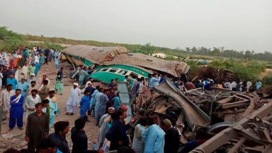 Pakistani local residents gather around the wreckage of carriages at the site where two trains collided in Rahim Yar Khan district of Punjab province on July 11, 2019. - At least 11 people were killed and nearly 80 injured when two trains collided in central Pakistan early July 11, officials said. The incident took place in Rahim Yar Khan district in Punjab province when a passenger train coming from the eastern city of Lahore rammed into a goods train that had stopped at a crossing, a senior government official said. (Photo by STR / AFP)