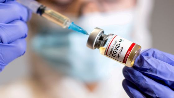 FILE PHOTO: A woman holds a small bottle labelled with a "Coronavirus COVID-19 Vaccine" sticker and a medical syringe in this illustration taken October 30, 2020. REUTERS/Dado Ruvic/File Photo