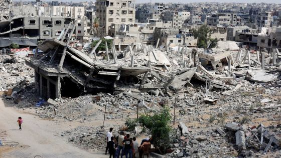 FILE PHOTO: Palestinians sit next to the rubble of houses destroyed in Israel's military offensive, amid the ongoing conflict between Israel and Hamas, in Khan Younis in the southern Gaza Strip October 7, 2024. REUTERS/Mohammed Salem/File Photo