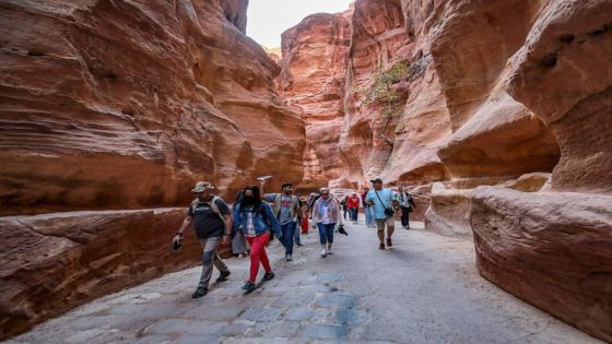 Tourists tour the ruins of the ancient Nabatean city of Petra in southern Jordan on December 12, 2022. - After years in which the Covid pandemic turned the storied "Rose City" into a ghost town, Jordan tourism authorities confirm that Petra, famous for its stunning temples hewn out of the rose-pink cliff faces, is back in business and drew 900,000 visitors last year, close to the previous record of one million set in 2019. (Photo by Khalil MAZRAAWI / AFP)