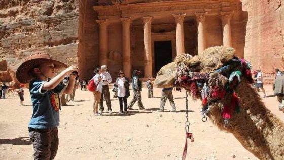 A tourist boy takes a picture of a camel at the Red Rose ancient city of Petra, southern Jordan, April 3, 2012. REUTERS/Ali Jarekji (JORDAN - Tags: POLITICS) - RTR30A8C