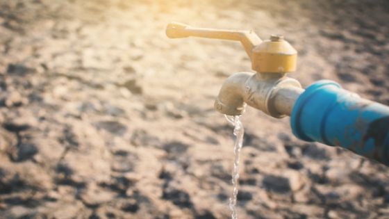 Faucet on cracked dry ground , concept drought and shortage of water