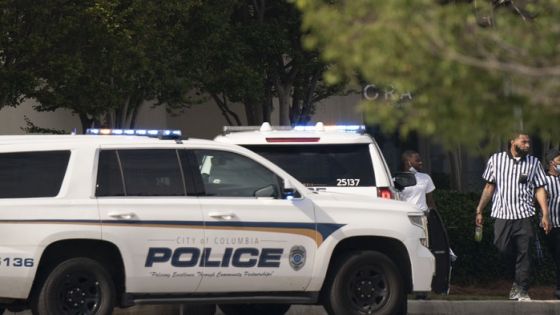 Foot Locker store employees walk near police vehicles outside Columbiana Centre mall in Columbia, S.C., following a shooting, Saturday, April 16, 2022. (AP Photo/Sean Rayford)