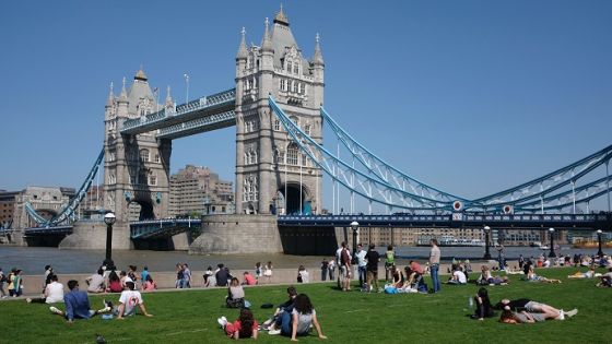 People relax in the hot and sunny weather on the grass beside Tower Bridge and the river Thames in London on May 26, 2017. Much of Britain enjoyed hot and sunny weather with temperatures above average for the time of year. / AFP PHOTO / DANIEL LEAL-OLIVAS (Photo credit should read DANIEL LEAL-OLIVAS/AFP/Getty Images)