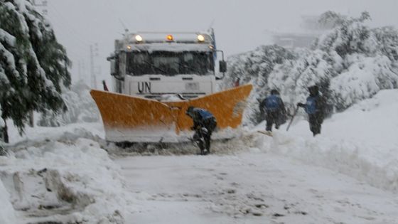 United Nations Interim Force in Lebanon (UNIFIL) peacekeepers shovel snow off the road leading to village of Kfar Kila in southern Lebanon, near the Lebanon-Israel border as a heavy storm hit the region on January 7, 2015. Heavy snowfall also cut several roads in mountainous areas of Lebanon, where more than a million Syrians fleeing civil war have claimed refuge in recent years. AFP PHOTO / STR / AFP / STR