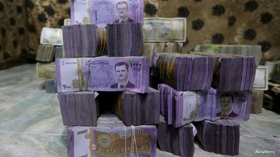 FILE PHOTO: Stacks of Syrian pounds are pictured inside an exchange currency shop in Azaz, Syria February 3, 2020. Picture taken February 3, 2020. REUTERS/Khalil Ashawi//File Photo