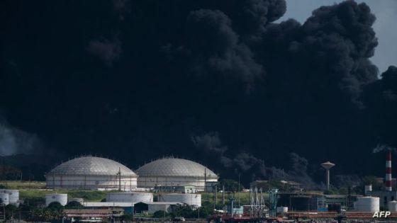 TOPSHOT - Black smoke from an oil tank on fire is seen in Matanzas, Cuba, on August 6, 2022. - The fire caused by lightning on Friday in a fuel depot in Matanzas, in western Cuba, spread to a second tank at dawn this Saturday and caused 49 injuries, official sources reported. (Photo by YAMIL LAGE / AFP)
