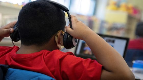 A student adjusts his headphones while watching a video during an in-person hybrid learning day at the Mount Vernon Community School in Alexandria, Virginia, U.S., March 2, 2021. Picture taken March 2, 2021. REUTERS/Tom Brenner