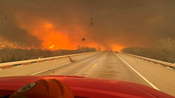 Cars drive as smoke and fire rise from wildfires in a location given as Texas, U.S., in this handout picture released on February 27, 2024. Greenville Fire-Rescue/Handout via REUTERS THIS IMAGE HAS BEEN SUPPLIED BY A THIRD PARTY. MANDATORY CREDIT. NO RESALES. NO ARCHIVES.