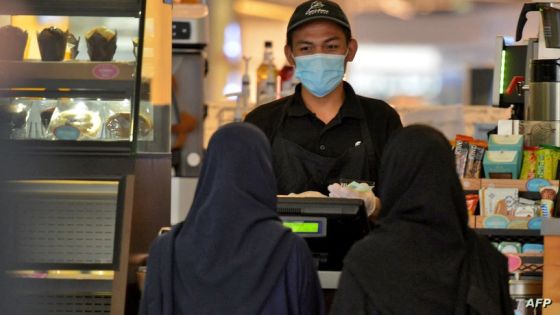 Women pick up their order from a restaurant in a shopping mall in the Saudi capital Riyadh on June 4, 2020, after it reopened following the easing of some restrictions put in place by the authorities in a bid to stem the spead of the novel coronavirus. (Photo by FAYEZ NURELDINE / AFP)