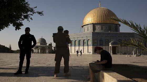An Israeli police officer stands guard as a religious Jew in Army uniform visits the Temple Mount, known to Muslims as the Noble Sanctuary, on the Al-Aqsa Mosque compound in the Old City of Jerusalem, Tuesday, Aug. 3, 2021. A ruling by a local Israeli court in favor of a Jewish man who prayed quietly at a flashpoint Jerusalem holy site has angered Muslim authorities, who denounced it on Thursday, Oct. 7, 2021 as a violation of the fragile status quo governing the compound. (AP Photo/Maya Alleruzzo, file)
