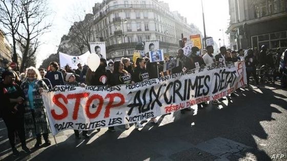 Protestors hold a banner reading "Stop state crimes" during a protest against racism organized by associations, unions and parties, in Paris, on March 19, 2022. (Photo by Christophe ARCHAMBAULT / AFP)