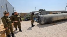 Members of the Israeli military stand next to an Iranian ballistic missile which fell in Israel on the weekend, during a media tour at the Julis military base near the southern Israeli city of Kiryat Malachi on April 16, 2024. Iran carried out an unprecedented direct attack on Israel overnight April 13-14, using more than 300 drones, cruise missiles and ballistic missiles, in retaliation for a deadly April 1 air strike on the Iranian consulate in Damascus. Nearly all were intercepted, according to the Israeli military. (Photo by GIL COHEN-MAGEN / AFP)