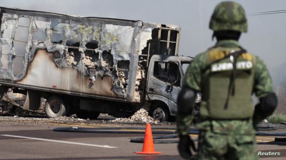 A soldier keeps watch near the wreckage of a burnt vehicle set on fire by members of a drug gang as a barricade, following the detention by Mexican authorities of drug gang leader Ovidio Guzman in Culiacan, a son of incarcerated kingpin Joaquin "El Chapo" Guzman, in Mazatlan, Mexico, January 5, 2023. REUTERS/Stringer NO RESALES. NO ARCHIVES