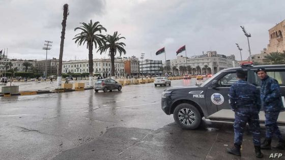 Policemen stand by a stationary patrol vehicle at the Martyrs' Square of Libya's capital Tripoli on December 13, 2021. (Photo by Mahmud Turkia / AFP)