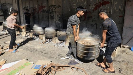 People cook on firewood, amid shortages of fuel and gas, to provide food for displaced Palestinians amid Israeli strikes in Khan Yunis, in the southern Gaza Strip October 15, 2023. Israeli forces were on October 15, readying for a looming Gaza ground invasion aimed at destroying Hamas, the Palestinian Islamist militant group that unleashed the bloodiest attack in the country's history. Thousands of people, both Israeli and Palestinians have died since October 7, 2023, after Palestinian Hamas militants based in the Gaza Strip, entered southern Israel in a surprise attack leading Israel to declare war on Hamas in Gaza on October 8. (Photo by Mahmud HAMS / AFP)