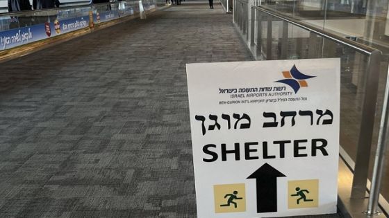 A sign informing passengers about the location of rocket shelters is set-up in a hallway as travelers arrive at Ben Gurion International Airport near Tel Aviv on October 10, 2023. Thousands have died and the toll continues to climb dramatically five days after Palestinian militants launched a surprise attack on Israel, which has responded with a massive bombardment of Gaza. (Photo by Yuri CORTEZ / AFP)