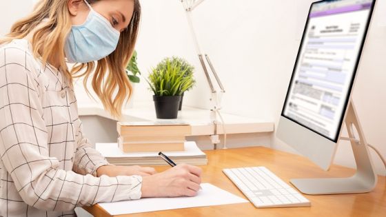 Young business woman working from home wearing protective mask