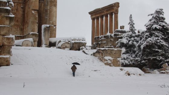 A visitor climbs the steps of Baalbek's Bachus temple as snow covers the Roman ruins of the historic town in eastern Lebanon's Bekaa Valley on January 9, 2013, following a fierce storm which has whipped the region this week with temperatures dropping dramatically and snow falling on low levels across Lebanon, Syria, Jordan and Israel. AFP PHOTO/STR (Photo credit should read STR/AFP/Getty Images)