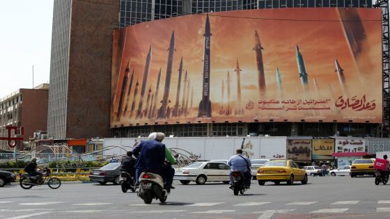 epa11293860 Iranians drive near an anti-Israel billboard carrying pictures of Iranian missiles and a sentence reading in Persian 'Israel is weaker than spider home' in Tehran, Iran, 22 April 2024. Tension between Iran and Israel continue since Iran's Islamic Revolutionary Guards Corps (IRGC) launched drones and missiles towards Israel on 13 April, following an airstrike on the Iranian embassy in Syria which Iran claimed was conducted by Israel. Iranian state media reported that three aerial objects were destroyed by air defense systems over the central city of Isfahan early morning on 19 April. EPA/ABEDIN TAHERKENAREH