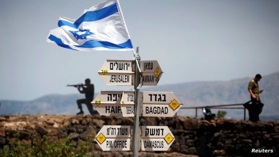 FILE PHOTO: An Israeli soldier stands next to signs pointing out distances to different cities, on Mount Bental, an observation point in the Israeli-occupied Golan Heights that overlooks the Syrian side of the Quneitra crossing, Israel May 10, 2018. REUTERS/Ronen Zvulun/File Photo