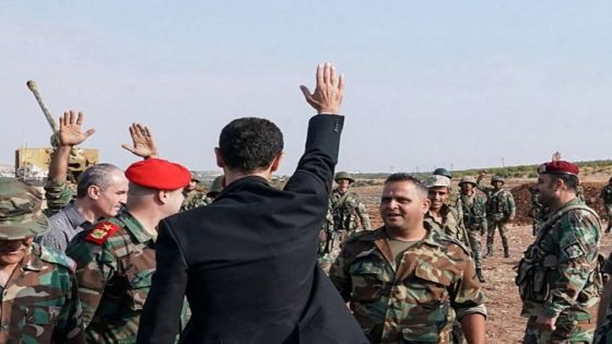 This handout picture released by the Syrian Presidency Facebook page on October 22, 2019, shows President Bashar al-Assad (C) waving his hand before Syrian army officers in al-Habit on the southern edges of the Idlib province. Assad visited government troops on the front line with jihadists in Idlib on October 22, his first visit to the northwestern province since the start of the conflict. (Photo by Syrian Presidency Facebook page / AFP) / RESTRICTED TO EDITORIAL USE - MANDATORY CREDIT "AFP PHOTO / Syrian Presidency Facebook page " - NO MARKETING NO ADVERTISING CAMPAIGNS - DISTRIBUTED AS A SERVICE TO CLIENTS