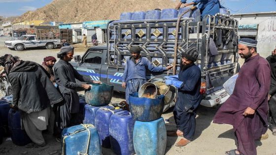TOPSHOT - This photograph taken on March 14, 2026 shows vendors filling their jerrycans with smuggled Iranian petrol, on the outskirts of Quetta in Balochistan province. (Photo by Banaras KHAN / AFP)