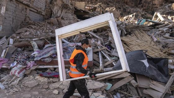 A volunteer helps salvage furniture from homes which were damaged by the earthquake, in the town of Imi N'tala, outside Marrakech, Morocco, Wednesday, Sept. 13, 2023. An aftershock rattled central Morocco on Wednesday, striking fear into rescue crews at work in High Atlas villages, digging people out from rubble that could slide. (AP Photo/Mosa'ab Elshamy)