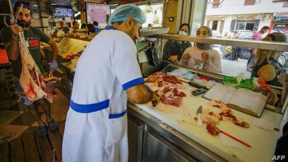 (FILES) This file photo taken on July 28, 2020 shows people waiting for their orders at a butcher in Lebanon's northern port city of Tripoli, as Muslims across the world are getting ready to celebrate Eid al-Adha. - Lebanon is grappling with an unprecedented financial crisis that the World Bank says is of a scale usually associated with fullscale wars. The currency has lost more than 90 percent of its value on the black market, more than 80 percent of the population lives in poverty, and prices have skyrocketed. The price of imported red meat has increased five fold, with some cuts costing more than the monthly minimum wage of 675,000 Lebanese pounds ($33). (Photo by IBRAHIM CHALHOUB / AFP)