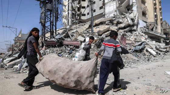 Boys walk with a large sack containing collected plastic past the rubble of a destroyed building in Rafah in the southern Gaza Strip on April 5, 2024 amid the ongoing conflict in the Palestinian territory between Israel and the militant group Hamas. (Photo by MOHAMMED ABED / AFP)