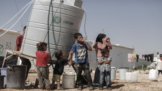 Hamoudi, 11, and his brother Mahmoud, 2 from Ghouta, near Damascus in Syria, collect drinking water from a water tank in Zataari camp in Jordan, which is home to around 80,000 Syrian refugees. Half of the camp's residents are under 16. (Photo by Sam Tarling/Corbis via Getty Images)