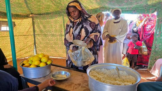 (FILES) A woman collects food at a location set up by a local humanitarian organisation to donate meals and medication to people displaced by the war in Sudan, in Meroe in the country's Northern State, on January 9, 2025. For the first time in nearly two years of war, soup kitchens in famine-stricken Sudan are being forced to turn people away, with US President Donald Trump's aid freeze gutting the life-saving schemes. (Photo by AFP)