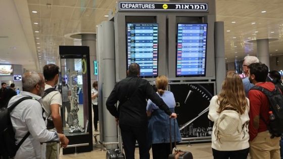 Passengers look at a departure board at Ben Gurion Airport near Tel Aviv, Israel, on October 7, 2023, as flights are canceled because of the Hamas surprise attacks. The conflict sparked major disruption at Tel Aviv airport, with American Airlines, Emirates, Lufthansa and Ryanair among carriers with cancelled flights. (Photo by GIL COHEN-MAGEN / AFP)