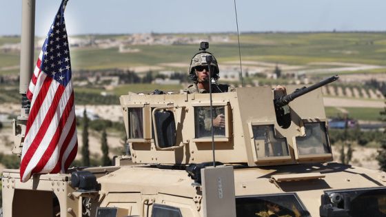 A U.S. soldier sits in an armored vehicle on a road leading to the tense front line with Turkish-backed fighters, in Manbij, north Syria, Wednesday, April 4, 2018. President Donald Trump expects to decide "very quickly" whether to remove U.S. troops from war-torn Syria, saying their primary mission was to defeat the Islamic State group and "we've almost completed that task." (AP Photo/Hussein Malla)