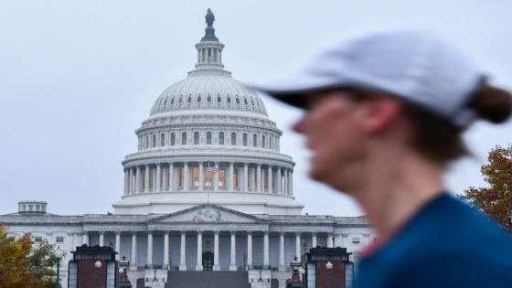 A woman passes in front of the US Capitol in Washington, District of Columbia, on November 6, 2018, as Americans started voting in mid-term elections that mark the first major voter test of Donald Trump's presidency, with control of Congress at stake. (Photo by MANDEL NGAN / AFP)