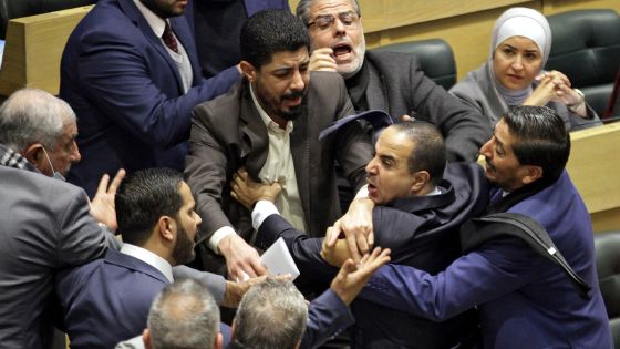 Jordanian parliament members are separated during an altercation in the parliament in the capital Amman on December 28, 2021. (Photo by AFP)