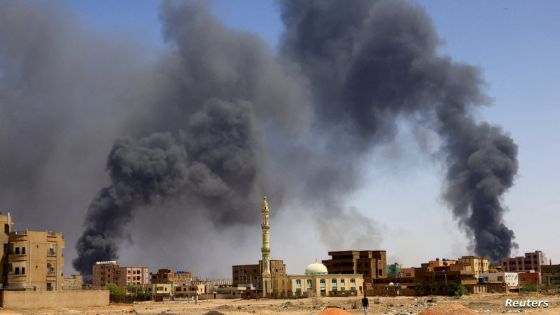 FILE PHOTO: A man walks while smoke rises above buildings after aerial bombardment, during clashes between the paramilitary Rapid Support Forces and the army in Khartoum North, Sudan, May 1, 2023. REUTERS/Mohamed Nureldin Abdallah/File Photo