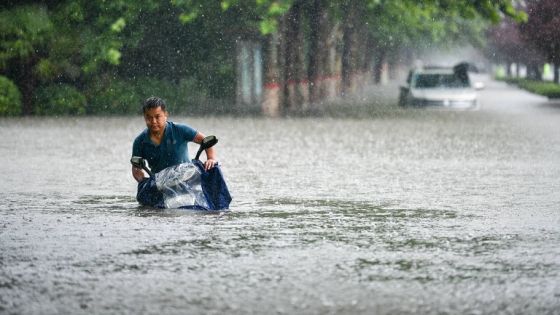 210720 -- ZHENGZHOU, July 20, 2021 -- A man rides on a waterlogged road in Zhengzhou, capital of central China s Henan Province, July 20, 2021. More than 144,660 residents have been affected by torrential rains in central China s Henan Province since July 16, and 10,152 have been relocated to safe places, the provincial flood control and drought relief headquarters said Tuesday. A total of 16 large and medium-sized reservoirs have seen water levels rise above the alert level after torrential rains battered most parts of the province on Monday and Tuesday. Photo by Hou Jianxun/Xinhua CHINA-HENAN-ZHENGZHOU-HEAVY RAINFALL CN LixAn PUBLICATIONxNOTxINxCHN