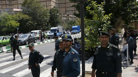 Police officers watch as a convoy carrying members of the British media leaves the British Embassy in Tehran, Iran August 23, 2015. Britain reopened its embassy in Tehran on Sunday, nearly four years after protesters ransacked the ambassador's residence and burned the Union Jack. In a signal of the most striking thaw in Western ties with Iran for over a decade, Foreign Secretary Philip Hammond watched the British flag being raised in the garden of the opulent 19th century building while the national anthem played. REUTERS/Darren Staples