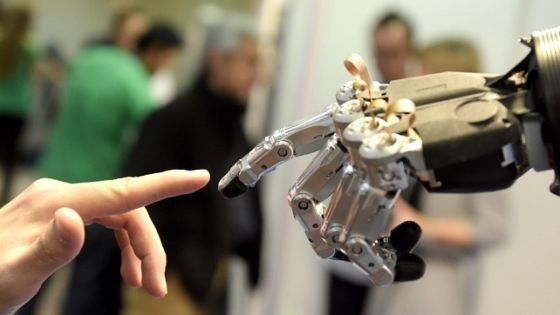 A man moves his finger toward SVH (Servo Electric 5 Finger Gripping Hand) automated hand made by Schunk during the 2014 IEEE-RAS International Conference on Humanoid Robots in Madrid on November 19, 2014. The conference theme "Humans and Robots Face-to-Face" confirms the growing interest in the field of human-humanoid interaction and cooperation, especially during daily life activities in real environments. AFP PHOTO/ GERARD JULIEN (Photo credit should read GERARD JULIEN/AFP/Getty Images)