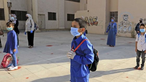 Students, wearing protective masks, wait in line on the first day of school in the Jordanian capital Amman amid the ongoing COVID-19 pandemic, on September 1, 2020. (Photo by Khalil MAZRAAWI / AFP)