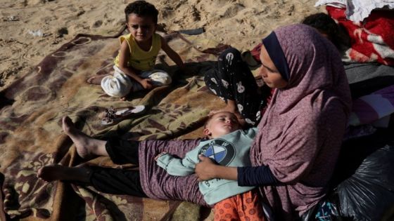 A woman sits with children outside, as displaced Palestinians, who fled their houses due to Israeli strike, shelter in a camp in Rafah, amid the ongoing conflict between Israel and Palestinian Islamist group Hamas, in the southern Gaza Strip, December 6, 2023. REUTERS/Ibraheem Abu Mustafa